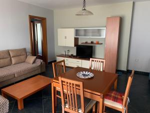 uma sala de estar com uma mesa e cadeiras e um sofá em Beachfront Apartament in Golem em Golem