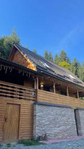 ein großes Holzgebäude mit einem Dach in der Unterkunft Hidden Valley in Băişoara