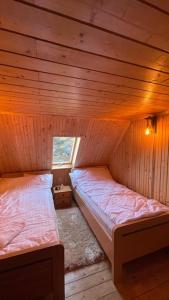 a room with two beds in a wooden cabin at Hidden Valley in Băişoara