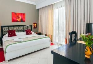 een hotelkamer met een bed, een bureau en een bureau bij Le Petit Palais Djerba & Spa in Houmt Souk