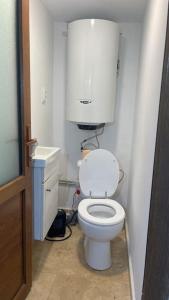 a bathroom with a white toilet with a water tank at Hidden Valley in Băişoara