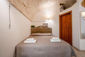 una camera da letto con un letto e due asciugamani di La Dimora di Agnese a Martina Franca
