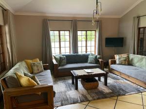 uma sala de estar com dois sofás e uma mesa de centro em Walkersons Trout and Nature Haven em Dullstroom