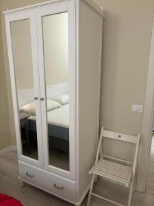 a white cabinet with a mirror next to a bed at Appartamento Albert in Livorno