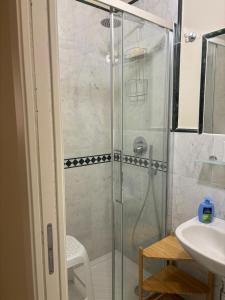 a shower with a glass door next to a sink at Appartamento Albert in Livorno