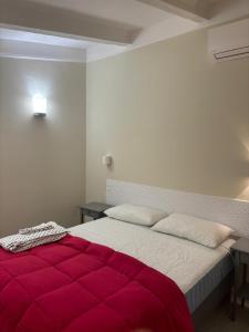 a bedroom with a large bed with a red blanket at Appartamento Albert in Livorno