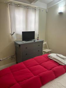 a bedroom with a large red bed and a desk at Appartamento Albert in Livorno