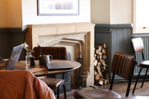 a table with two laptops on top of a fireplace at The Swan at Forest Row in Forest Row