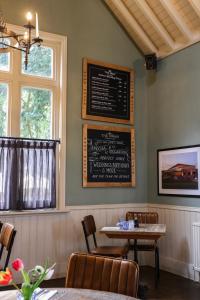 ein Restaurant mit einem Tisch und einer Tafel an der Wand in der Unterkunft The Swan at Forest Row in Forest Row