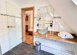 ein Bad mit einem Waschbecken und einem Spiegel in der Unterkunft Landgasthof Rebstock in Ottenhöfen