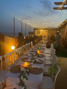 a long long table with white chairs and lights at LA SUNSET in Accra