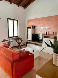 - un salon avec un canapé rouge et une télévision dans l'établissement CASA GIULIA, à Monzambano