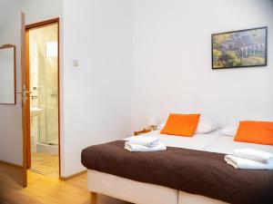 1 dormitorio con 1 cama con almohadas de color naranja y blanco en Station Aparthotel, en Cracovia