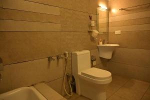 La salle de bains est pourvue de toilettes et d'un lavabo. dans l'établissement The White Bloom 3BHK, à Munnar
