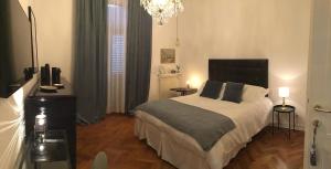 een slaapkamer met een bed en een kroonluchter bij Garden View boutique apartments in Gorizia