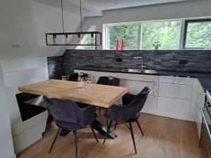 a kitchen with a wooden table and chairs at Natuurhuisje Meppen in Meppen