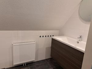 een witte badkamer met een wastafel en een wastafel bij Natuurhuisje Meppen in Meppen