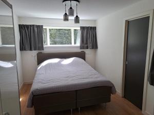 - une chambre avec un lit et une fenêtre dans l'établissement Natuurhuisje Meppen, à Meppen