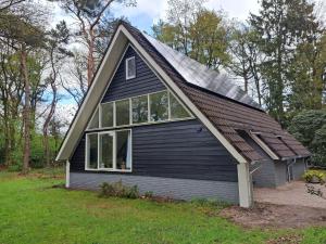 une maison noire avec un toit en gambrel dans l'établissement Natuurhuisje Meppen, à Meppen