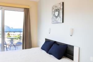 1 Schlafzimmer mit einem Bett und einem Balkon mit einem Tisch in der Unterkunft Sun and Sea in Karpathos