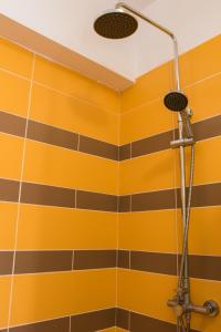 eine Dusche im Bad mit gelben und schwarzen Streifen in der Unterkunft Sun and Sea in Karpathos