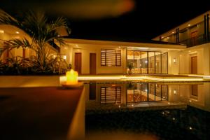 une maison avec une bougie éclairée devant elle la nuit dans l'établissement Cocotree Resort, à Panglao