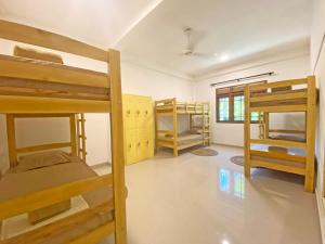 a room with three bunk beds and a window at MAKAI Surf House in Ahangama