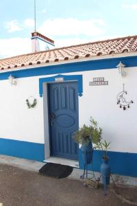 un edificio azul y blanco con una puerta azul en Rosa Mar, en Cabeça de Carneiro