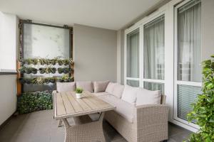 eine Veranda mit einem weißen Sofa und einem Tisch in der Unterkunft Złoty Potok Modern Family Apartment with Balconies & Parking Warsaw by Renters in Warschau