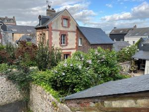 an old brick building in a city with bushes at Lovely cottage in Honfleur center in Honfleur
