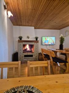 a living room with a fireplace and a table at Guest house Zeder in Jezerce