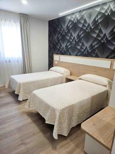 a hotel room with three beds and a window at A Quinta de Cea in Cea