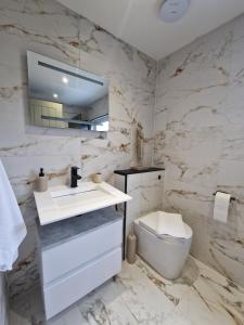 ein weißes Badezimmer mit Waschbecken und Toilette in der Unterkunft Modern Detached 3 bedroom home with off-road parking & bike store in Abercanaid + 16 Fotos