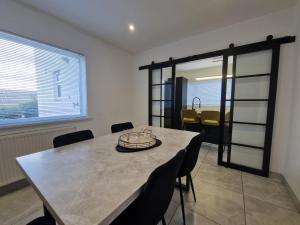 a dining room with a table and chairs and a window at Modern Detached 3 bedroom home with off-road parking & bike store in Abercanaid
