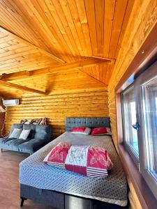 ein Schlafzimmer mit einem Bett in einem Blockhaus in der Unterkunft Къща за Гости in Ivanyane