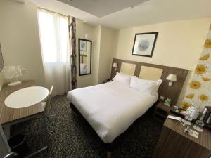a hotel room with a large bed and a table at Holiday Inn Paris Opéra - Grands Boulevards, an IHG Hotel in Paris