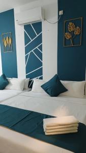 a room with two beds with blue walls at Olive Hotel in Johor Bahru