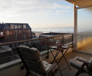 a balcony with two chairs and a table with a view at Apartment mit Meeresblick Wangerooge in Wangerooge +31 photos
