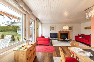 a living room with red furniture and a large window at Feriensiedlung Trü 2 in Scuol