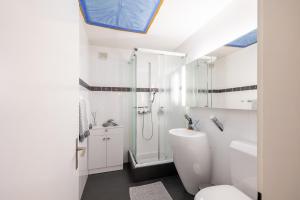 a white bathroom with a shower and a toilet at Feriensiedlung Trü 2 in Scuol +14 photos