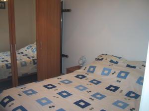 um quarto com uma cama com um edredão azul e branco em Residente TOPAZE DE PANNE GEM 1 SLPK APP LUXE AFW & Ruime parking incl em De Panne