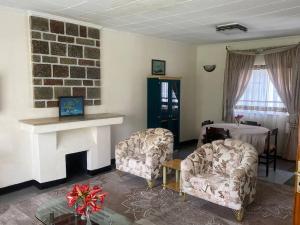 a living room with two chairs and a fireplace at 3 Bedroom Villa with Garden in Addis Ababa Bole in Addis Ababa
