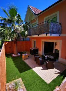 une arrière-cour avec une terrasse et une pelouse dans l'établissement Appartement 90 m2 avec parking terrasse balcons, proche du port et plages, à Arcachon