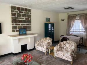 a living room with two chairs and a fireplace at 3 Bedroom Villa with Garden in Addis Ababa Bole in Addis Ababa