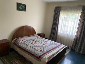 a bed with a quilt on it in a bedroom at 3 Bedroom Villa with Garden in Addis Ababa Bole in Addis Ababa