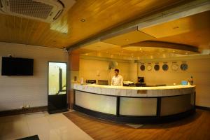 a man standing at a counter in a restaurant at Fu Wang Dominous Resort in Cox's Bazar