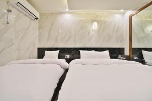 Habitación con 2 camas blancas y paredes de mármol. en Deagu Hotel Rubato RB en Daegu