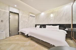 two beds in a room with white walls at Deagu Hotel Rubato RB in Daegu