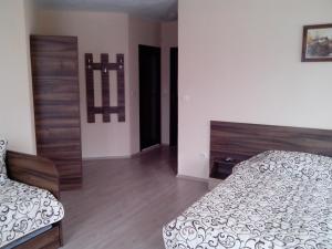 a bedroom with two beds and a wooden floor at Advel Guest House in Madzhare