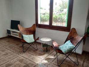 sala de estar con 2 sillas y TV en Casa Tritons, en Puerto de Alcudia